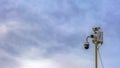 Panorama frame Outdoor security camera isolated against a cloudy blue sky background Royalty Free Stock Photo