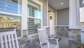 Panorama frame Porch with rocking chairs and door with wreath viewed at the facade of a home Royalty Free Stock Photo