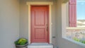 Panorama frame The red front door of a house with concrete exterior wall and shutters on window Royalty Free Stock Photo