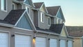 Panorama frame Selective focus of townhomes with white garage doors against mountain and sky Royalty Free Stock Photo