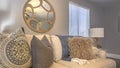 Panorama frame Sofa with fluffy pillows inside a living room with round mirror and gray wall