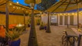 Panorama frame Stone brick patio of a home illuminated with string lights and lamp posts