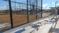 Panorama frame Tiered bleachers with metal handrail at a sports field viewed on a sunny day
