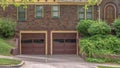 Panorama frame Two car garage with glass panes on door of a house with brick exterior wall Royalty Free Stock Photo