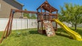 Panorama frame Wooden playground structure with yellow plastic slide swings and climbing wall