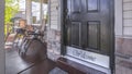 Panorama Front door of house with glass panes and porch with chairs railings and columns Royalty Free Stock Photo