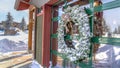 Panorama Frosted wreath on the glass wall of building that reflects the winter landscape