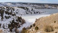 Panorama Frozen lake and hills blanketed with snow under cloudy blue sky in winter Royalty Free Stock Photo