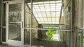 Panorama Glass door and wall with view of slanted frosted roof over stairway of building