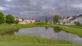 Panorama Grassy park with pond and pathways in the middle of lovely multi storey homes
