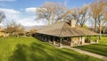 Panorama Grassy terrain with pavilion trees and homes under sky and clouds on a sunny day