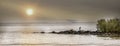 Panorama of a Great Blue Heron standing on a rock jetty with the