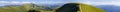 Panorama of green hills in summer mountains with gravel road for Royalty Free Stock Photo