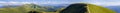 Panorama of green hills in summer mountains with gravel road for Royalty Free Stock Photo