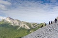 Panorama of a group of mountain climbers hiking up a mountain side to a hard climbing route