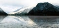 Panorama of Hallstatt lake outdoor snow mountains with reflection in the water in Austria in Austrian alps