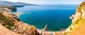 Panorama of high cliffs, Tyrrhenian sea bay with pure azure water, floating boats and ships, pebble beaches, rocky surroundings of