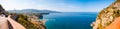 Panorama of high cliffs, Tyrrhenian sea bay with pure azure water, floating boats and ships, pebble beaches, rocky surroundings of