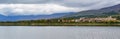 panorama of a high mountain village on the shore of the lake with large clouds in dramatic sky Royalty Free Stock Photo