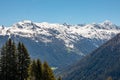 Panorama of high partly snowy mountains at blue sky