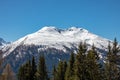 Panorama of high partly snowy mountains at blue sky