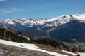 Panorama of high partly snowy mountains at blue sky