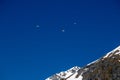 Panorama of high partly snowy mountains with paragliders