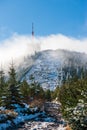 Panorama of hill Lysa hora in misty clouds during sunrise Beskydy Mountains. Transmitter on Lyse mountain. Early morning in Beskid