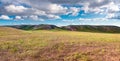 Panorama hills in sunny day. Vista scenic idylic landscape hills sun through the clouds meadow Royalty Free Stock Photo