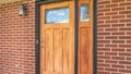 Panorama Home with brick and wood wall sections and glass paned front door and sidelight