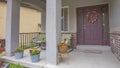 Panorama Home facade with rocking chairs and potted flowers on the concrete porch