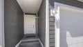 Panorama Home facade with view of the white front door and garage door on a sunny day