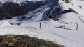 Panorama horizontal. Many people start skiing on a well-groomed ski slope at a ski resort. The sun is shining and the