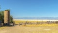 Panorama Huge cylindrical containers and old wooden fences against lake and mountain