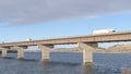 Panorama Huge trucks travelling on a massive bridge against snowy hills and cloudy sky