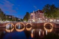 Panorama of the illuminated bridges on the channels at night. Cityscape of Amsterdam, the Netherlands