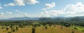 Green trees and mountain hill with blue sky and white clouds in background. Royalty Free Stock Photo