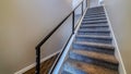Panorama Indoor stairs of home with metal handrail and gray carpet on the treads