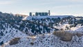 Panorama Industrial building on top of a rugged snowy mountain against cloudy sky