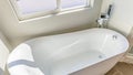 Panorama Interior of a bathroom with a smooth and glossy bathtub in th corner