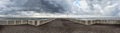 Panorama from the jetty to rough sea with scenic sky covered by clouds ready for the rain at distance a man alone looking the sea