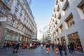 Panorama of Karntner street with people shopping in stores around. Karntnerstrasse is the main pedestrian street