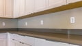 Panorama Kitchen interior of a house with white cabinets below the gleaming countertop Royalty Free Stock Photo