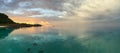 Panorama of the lagoon around Bora Bora, French Polynesia at dawn with a mountain and overwater bungalows; landscape