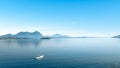 Panorama Of Lake Maggiore In Italy, A Small White Sailboat Sailing On The Lake