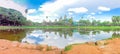 Panoramic view Angkor Wat facade under construction and palm tree reflection on the lake