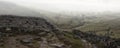 Panorama landscape foggy Autumnal view over limestone crag to va