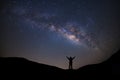 Panorama landscape with milky way, Night sky with stars and silhouette of a standing sporty man with raised up arms on high mount Royalty Free Stock Photo