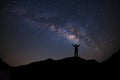 Panorama landscape with milky way, Night sky with stars and silhouette of a standing sporty man with raised up arms on high mount Royalty Free Stock Photo