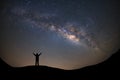 Panorama landscape with milky way, Night sky with stars and silhouette of a standing sporty man with raised up arms on high mount Royalty Free Stock Photo